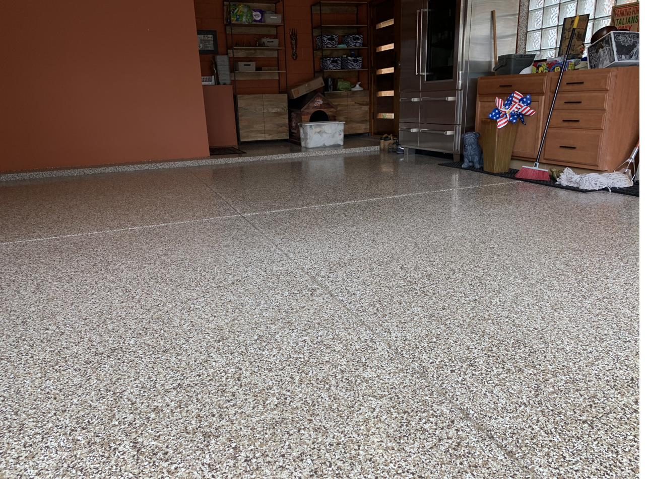 Warm tan and brown flake epoxy floor in a finished garage living space